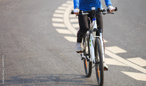Young Woman Cyclist Riding Mountain Bike on city road