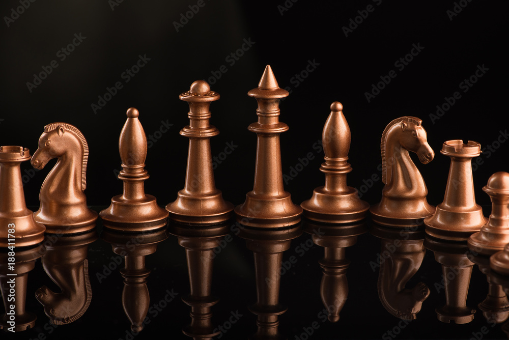 gold chess pieces on a black glossy