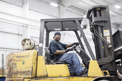 Portrait of manual worker driving forklift at metal Steel Mill photo