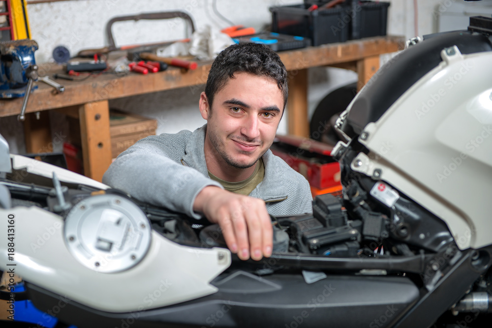 young man repairing the motorcycle young man repairing the motorcycle