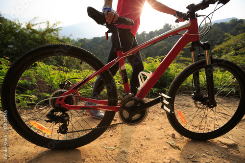 Riding mountain bike on forest trial during sunrise