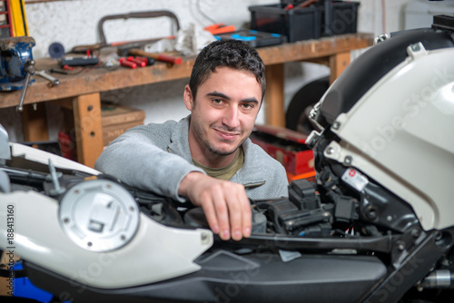 young man repairing the motorcycle