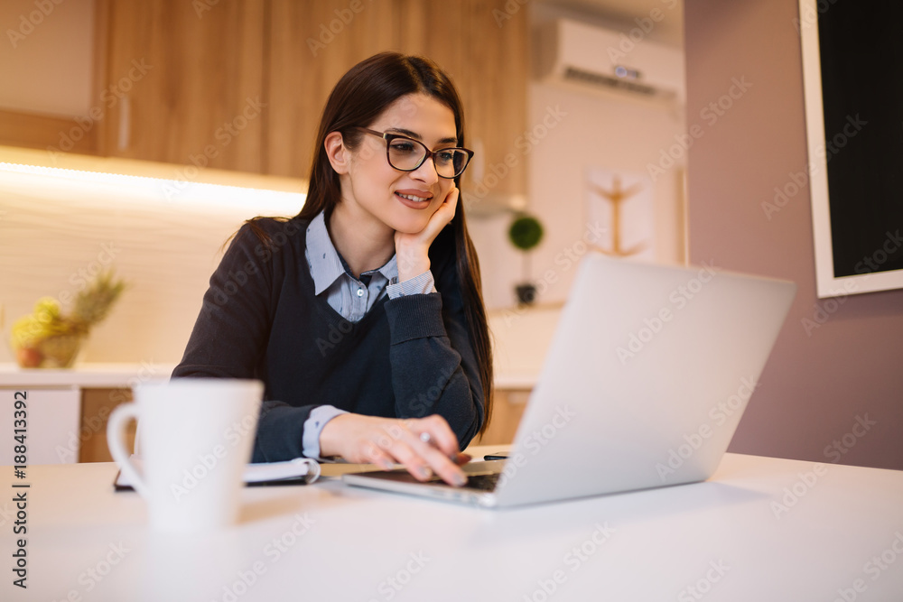 Pretty girl with eyewear working on her laptop from home. Pretty girl with eyewear working on her laptop from home.