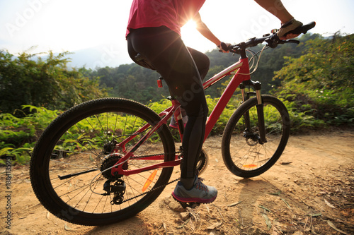 Riding mountain bike on forest trial during sunrise . © lzf