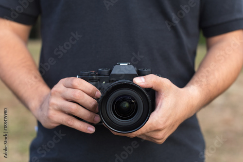 photographer hold DSRL camera in his hands. Photography or traveler Concept © sarunchana