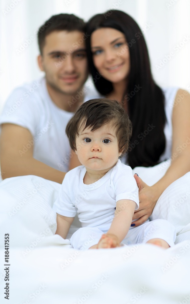 Happy couple and son sitting in bed Happy couple and son sitting in bed