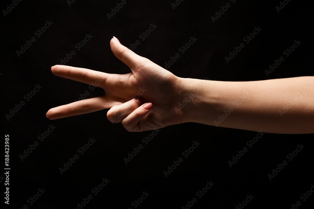 Female hand shows number two isolated at black Female hand shows number two isolated at black