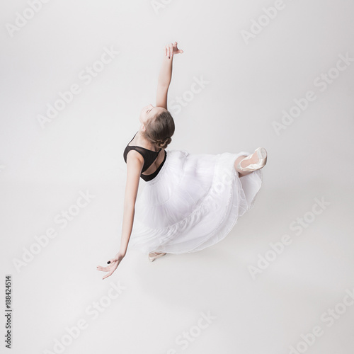 Fototapeta Naklejka Na Ścianę i Meble -  The top view of the teen ballerina on white background