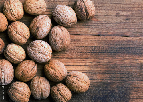 few closed ripen walnuts on an old walnut board