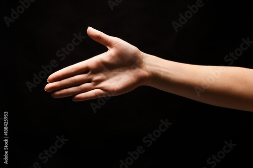 Hand ready for handshake isolated on black