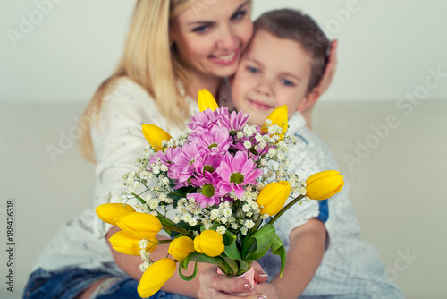 Son gives his beloved mother a beautiful bouquet of tulips.The concept of the celebration,women's day. 