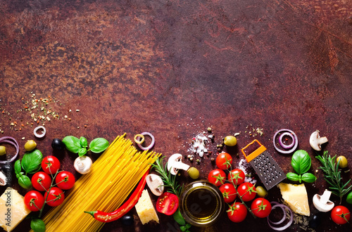 Food ingredients for italian pasta, spaghetti on brown dark background. Copy space of your text