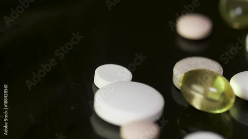 Various colorful pills on black background. Pile of several medicines on black background. Colorful pills over dark background. white pills on black glass background. medical pharmacy photo