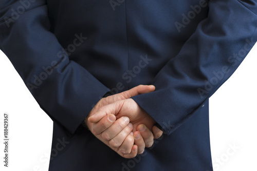 Businessman standing with folded hands behind the back