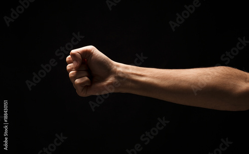 Hand gesture, man clenched fist, ready to punch isolated on black