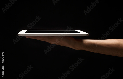 Man holding digital tablet with blank screen isolated on black