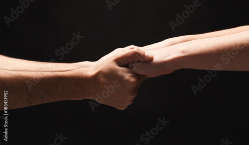 Hands of man and woman in love, isolated on black