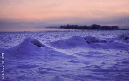 Beautiful winter landscape. Frozen river covered with snow. Sunset in ices. Ice hummocks © es0lex