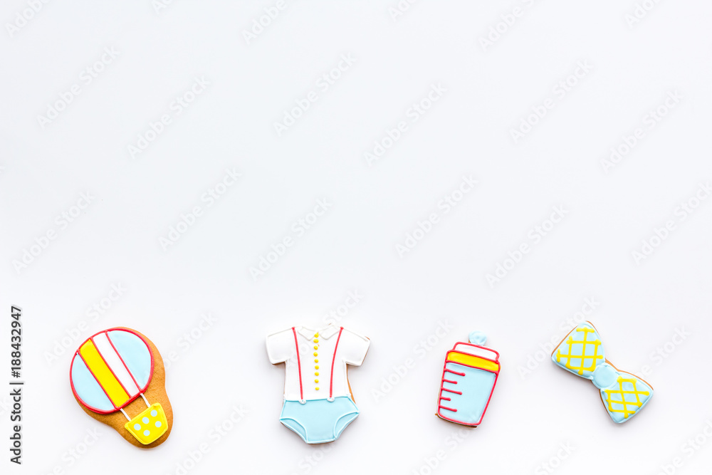 Bith of child concept. Cookies in shape of baby cloth and baby bottle on white background top view copy space Bith of child concept. Cookies in shape of baby cloth and baby bottle on white background top view copy space