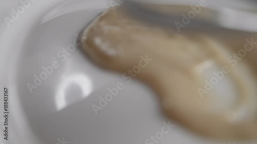 Close up, chef spreads sauce on plate