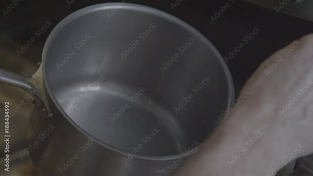 Slow motion, chef ladles oil into pot Slow motion, chef ladles oil into pot