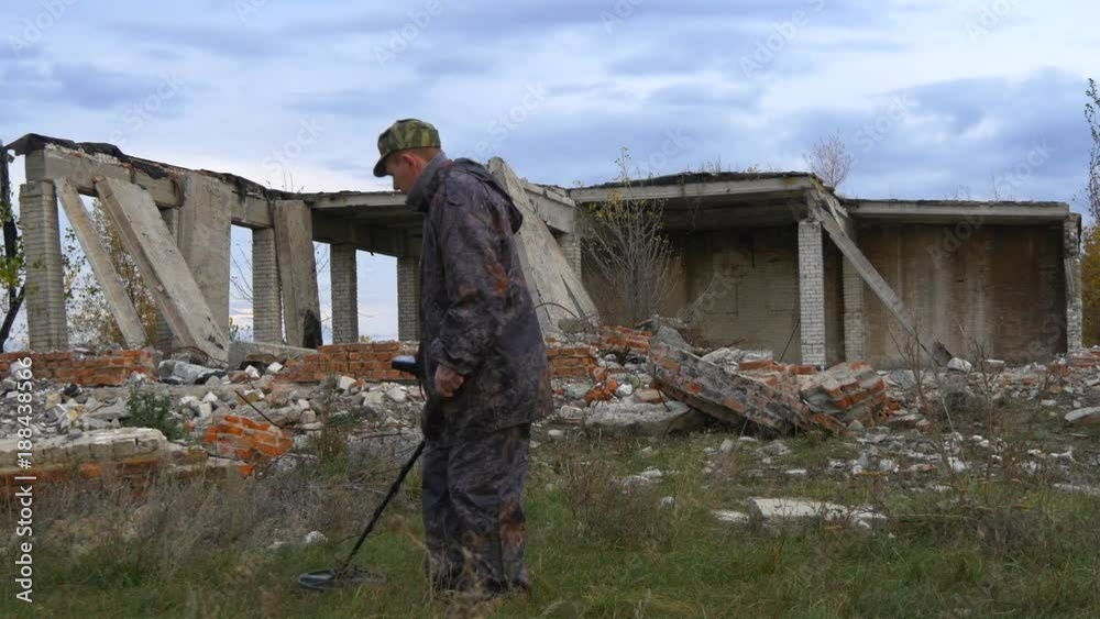 The soldier works with a mine detector in the ruins of houses in search of mines and explosives The soldier works with a mine detector in the ruins of houses in search of mines and explosives