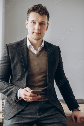 Foto Portrait of a handsome charismatic man in a formal stylish suit with a smartphon