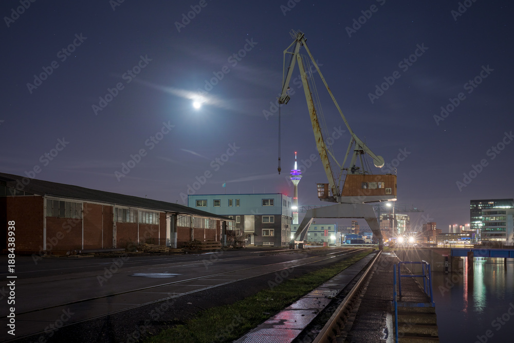 Illuminated Rhinetower Of Duesseldorf At Night Taken From Harbour With Crane In Front Illuminated Rhinetower Of Duesseldorf At Night Taken From Harbour With Crane In Front