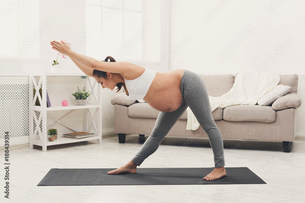 Happy pregnant woman training yoga at home Happy pregnant woman training yoga at home