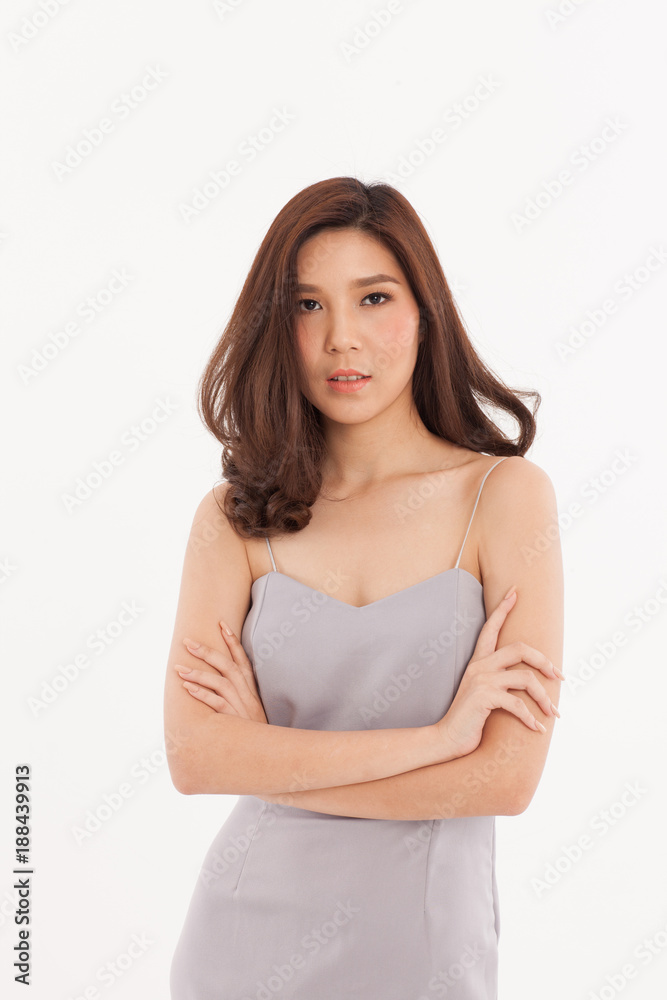 An attractive Asian girl in light grey dress smiling on white background. An attractive Asian girl in light grey dress smiling on white background.