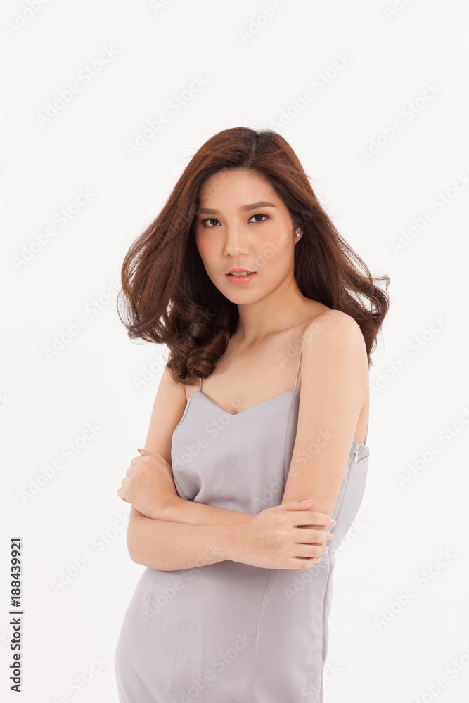 An attractive Asian girl in light grey dress smiling on white background. An attractive Asian girl in light grey dress smiling on white background.
