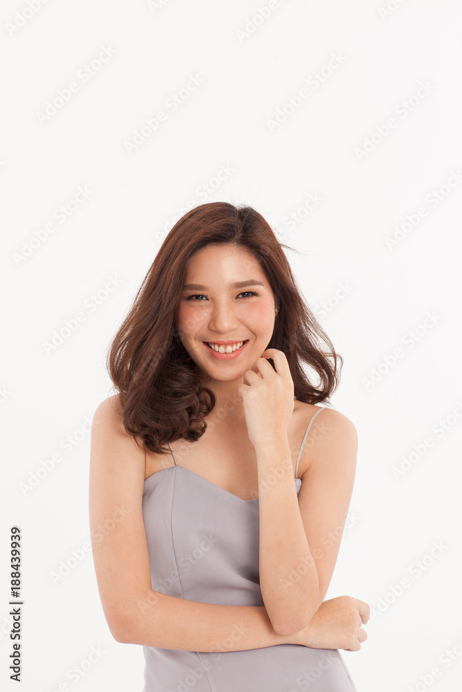An attractive Asian girl in light grey dress smiling on white background. An attractive Asian girl in light grey dress smiling on white background.