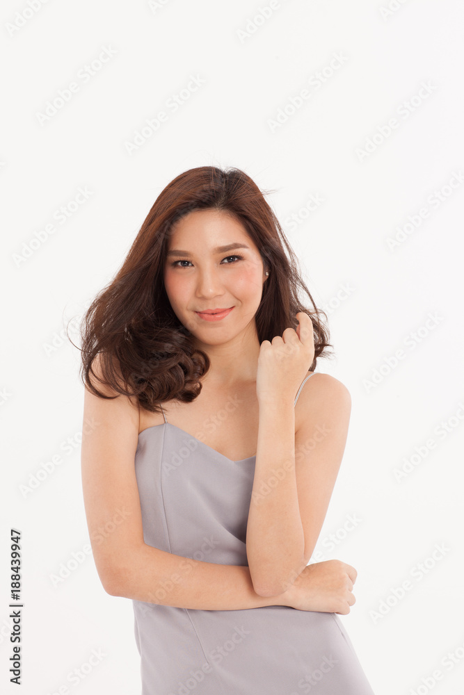 An attractive Asian girl in light grey dress smiling on white background. An attractive Asian girl in light grey dress smiling on white background.