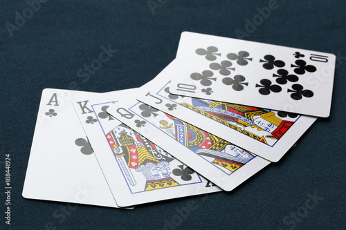 Royal flush (poker hand) of clubs on a dark background