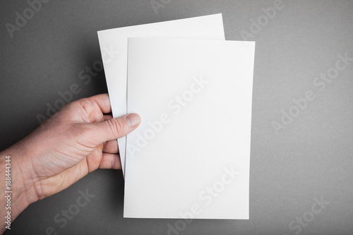 Blank brochure magazine isolated on grey, with clipping path in man hand.