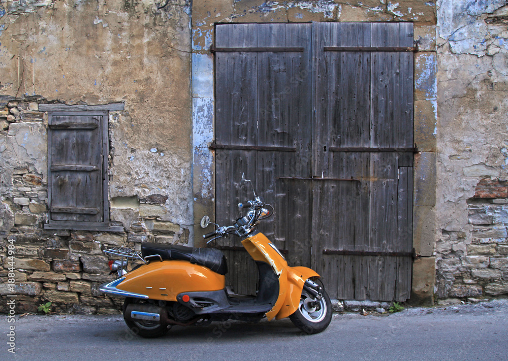 street in old village with wood door and old scooter