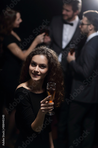 stylish young woman raising a glass of champagne