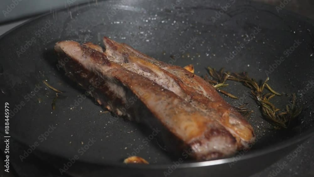 Rack of lamb. Cooking with fire in frying pan. Professional chef in a commercial kitchen cooking. Man frying food in pan on hob in kitchen. slow motion Rack of lamb. Cooking with fire in frying pan. Professional chef in a commercial kitchen cooking. Man frying food in pan on hob in kitchen. slow motion