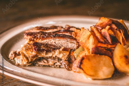 Closeup of a meat meal with potatoes on a rustic plate