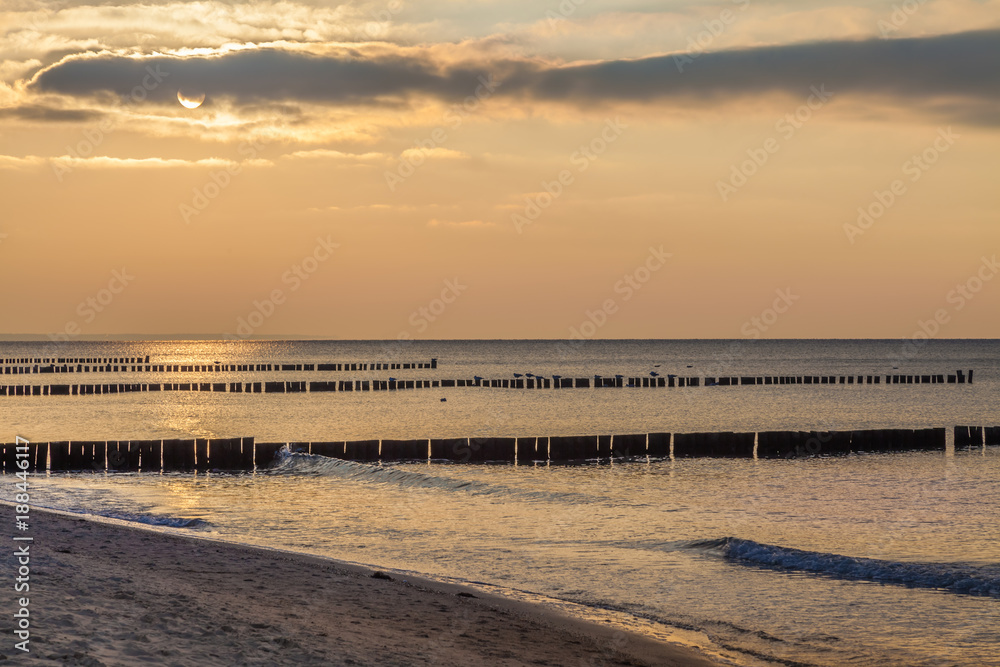 Am Strand der Ostsee bei Sonnenuntergang mit Blick über die Buhnen bei Wustrow