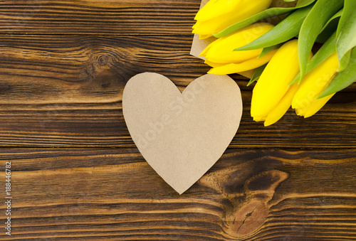 paper heart, yellow tulips on wooden table
