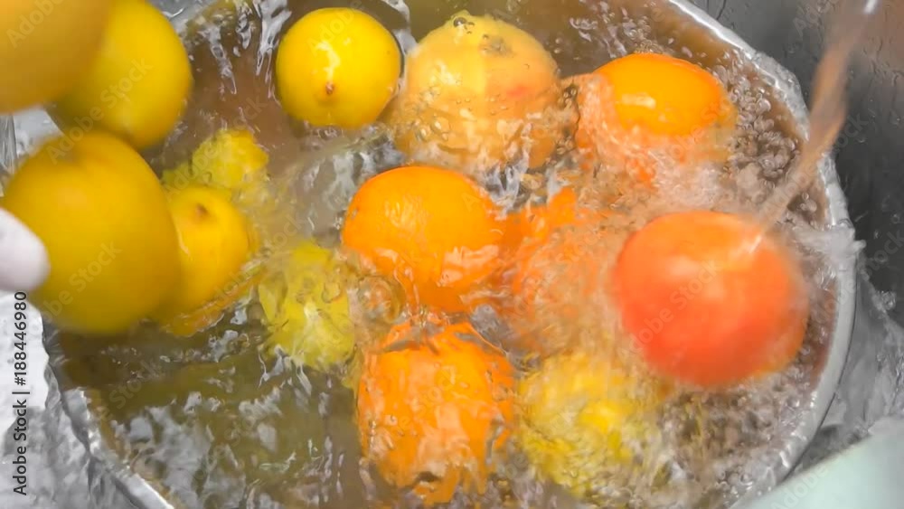 Close up citrus fruits falling in a water. Top view orangers, lemons and limes falling in a bowl full of water. Close up citrus fruits falling in a water. Top view orangers, lemons and limes falling in a bowl full of water.
