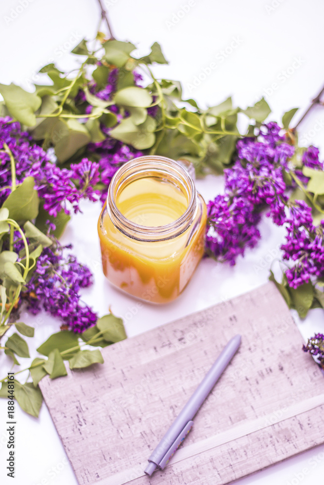 Notebook,delicious orange juice and lavander flowers on a white table
