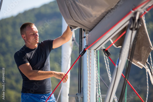 Canvas-taulu A young male sailor setting sail on his yacht.