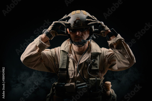 special forces soldier of the united states poses with a rifle on a black background © superelaks
