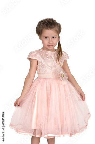 The girl in a pink ball dress and with blue eyes stands at a wall. She hesitates.