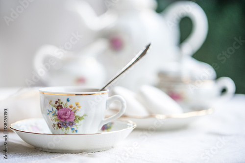 Photography Luxury porcelain tea set with a cup, teapot, sugar bowl on white tablecloth