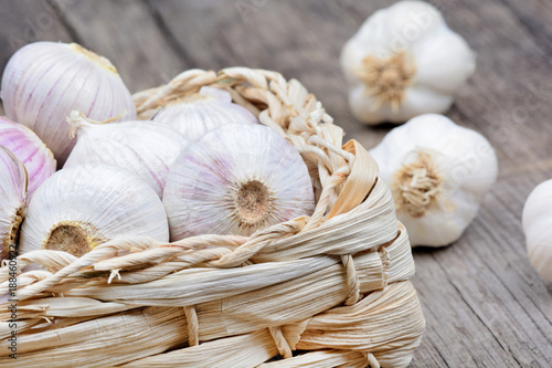 Heap of garlic in a wicker basket on table