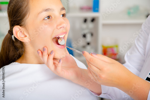 Close-up of little girl opening his mouth wide during treating...