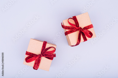 Craft box with red ribbon bow. Valentine day concept. Trendy minimalistic flat lay design background © Ekaterina_Molchanova